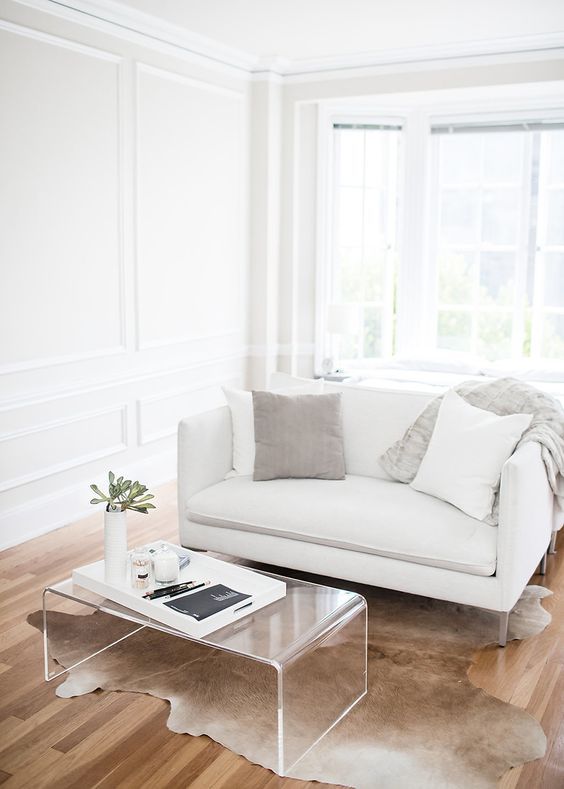 Minimalist Living Room with Lucite Coffee Table via The Every Girl