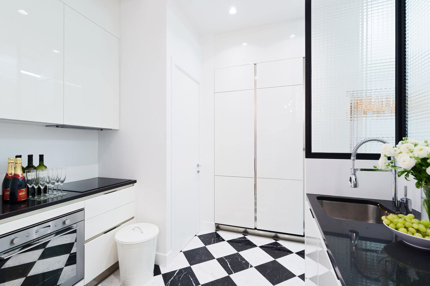 https://curatedinterior.com/wp-content/uploads/2020/07/Parisian-kitchen-with-Black-and-White-Checkered-Floors-via-havenin-saint-Honore.jpg