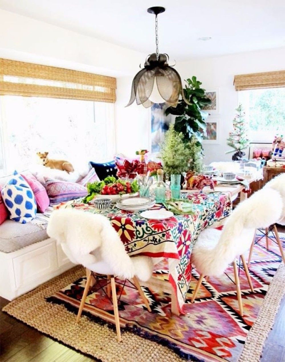 Boho Dining Room with Colored Rug Layered Over Beige Jute Rug via Le Journal de la Maison