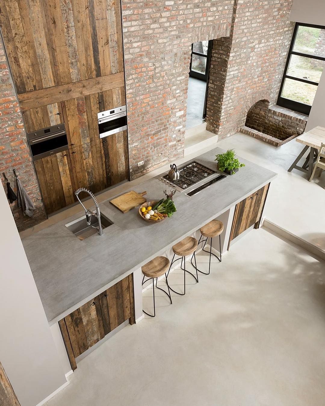 Concrete Countertops in Industrial Kitchen with Exposed Brick Walls and Rustic Wood Panels via @cavainterieur