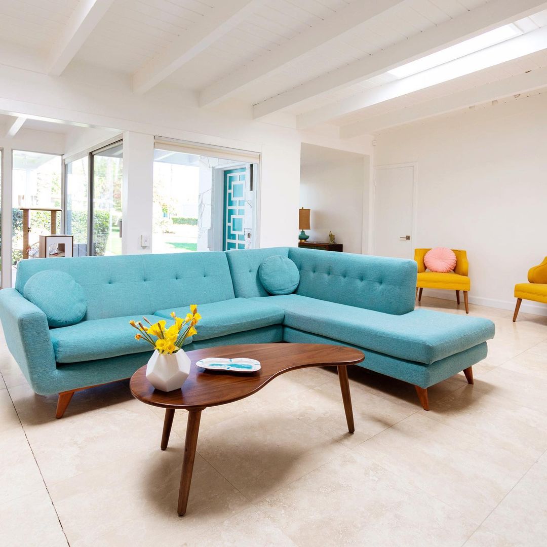 Mid-Century Modern Living Room with Turquoise Sectional Sofa and Curving Wood Coffee Table via @melodrama