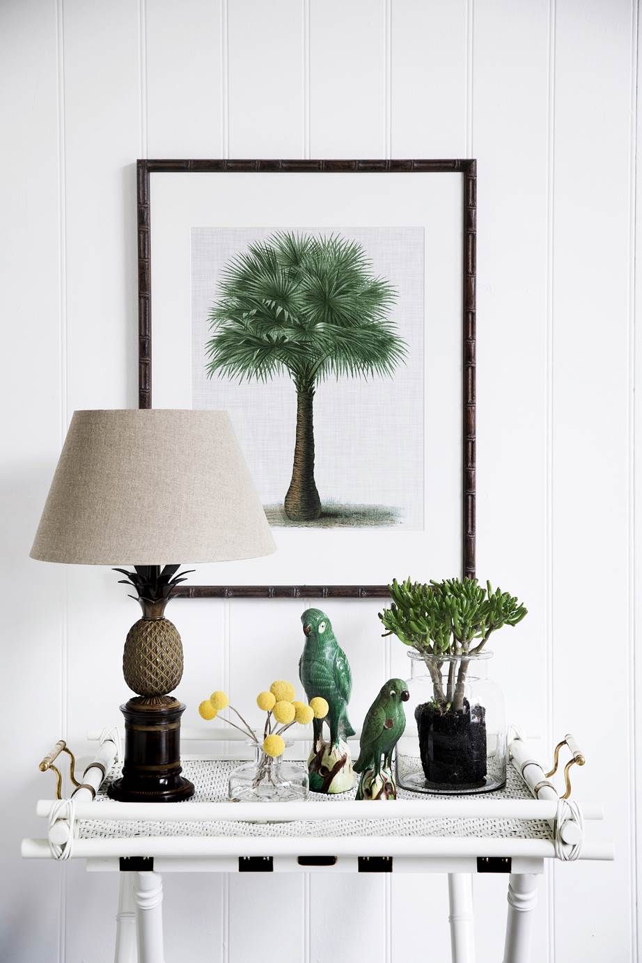 Parrot Decor on white rattan console table via homestolove.com.au