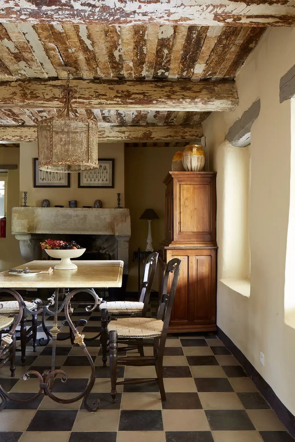 Black and white ceramic tile floor in English Country Dining Room with wrought iron base table via Jocelyn Sibuet House and Garden