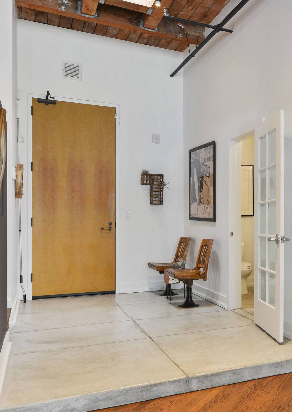 Factory Style Old Chairs in an Industrial Foyer Entryway with Concrete Floors via Melissa Winn Interiors