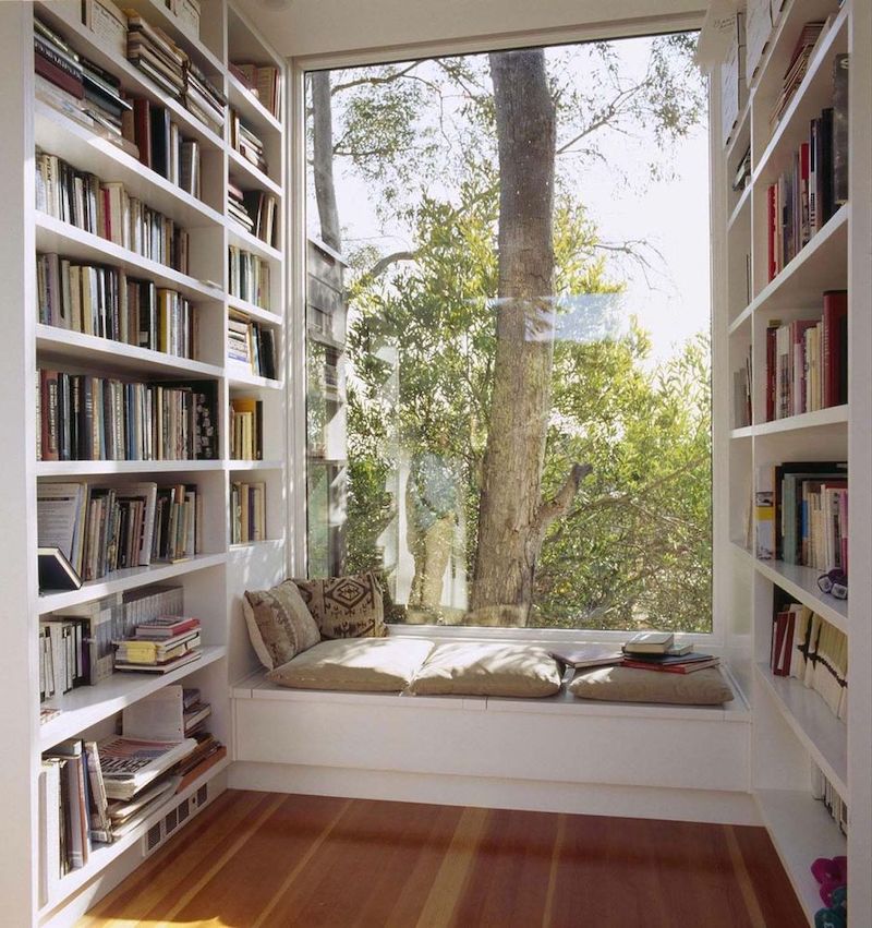 Reading Nook with Built-in Bookshelves and Trees Outside the Window