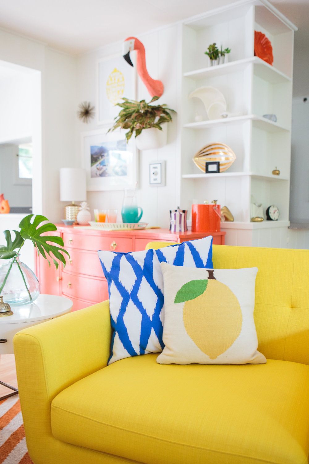 Tropical Living Room with Graphic Lemon Print Pillow on Yellow Sofa via Shelby Girard