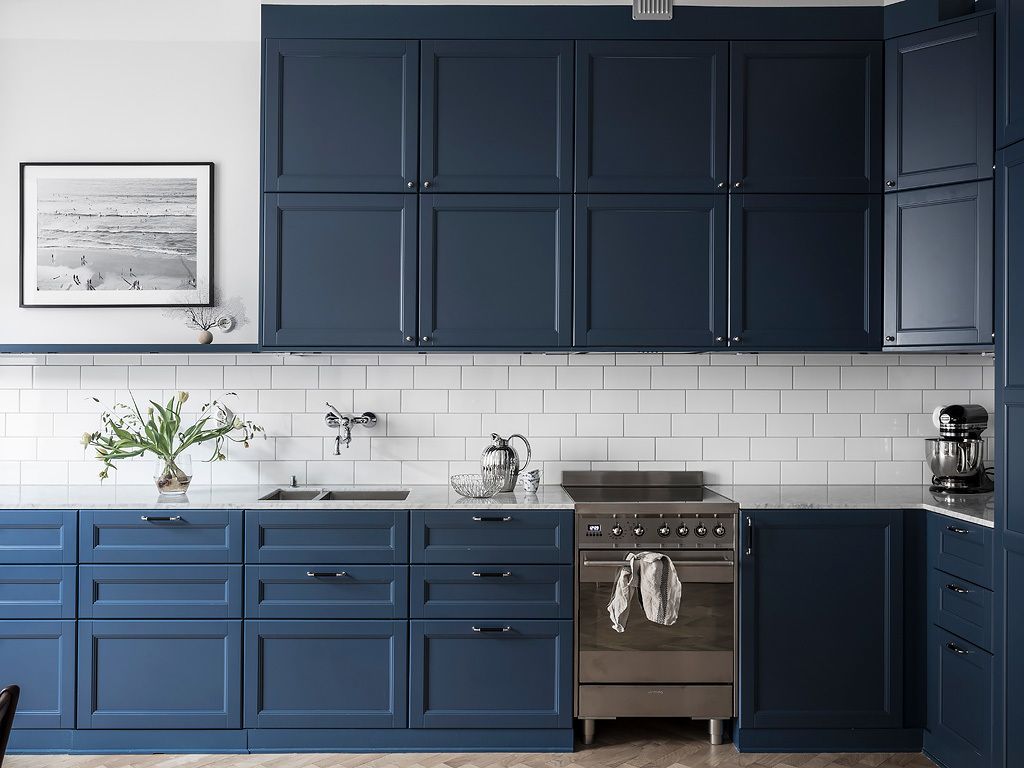 White Subway Tile Backsplash and Scandinavian Blue Cabinets in Nordic Kitchen via entrancemakleri