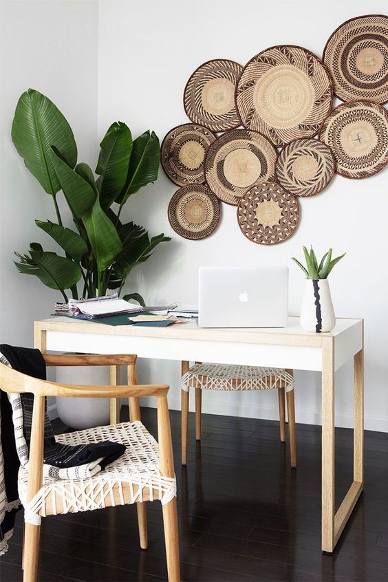 Woven wall baskets on wall of Bohemian office decor with woven leather chairs