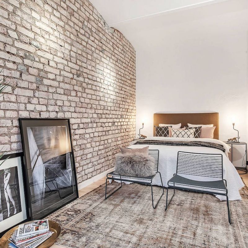 Black and White Photography and Brick Accent Wall in Industrial Bedroom Decor via Celon Stockholm