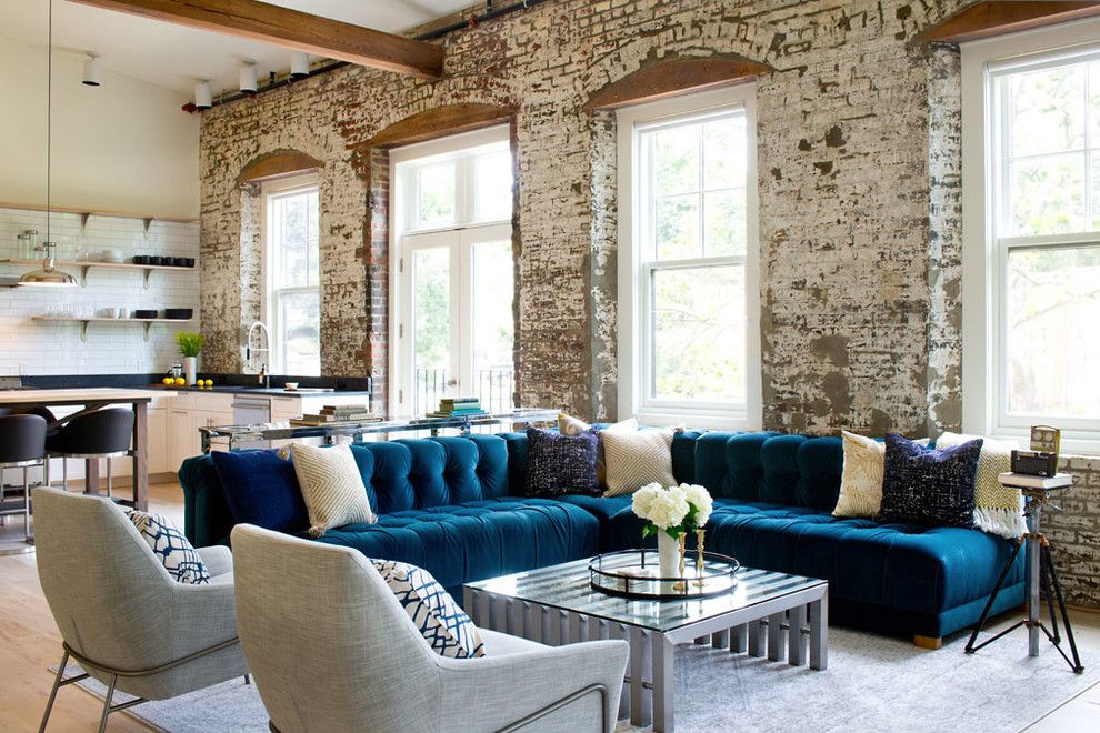 Blue velvet tufted sofa in industrial living room design via Grisoro Designs