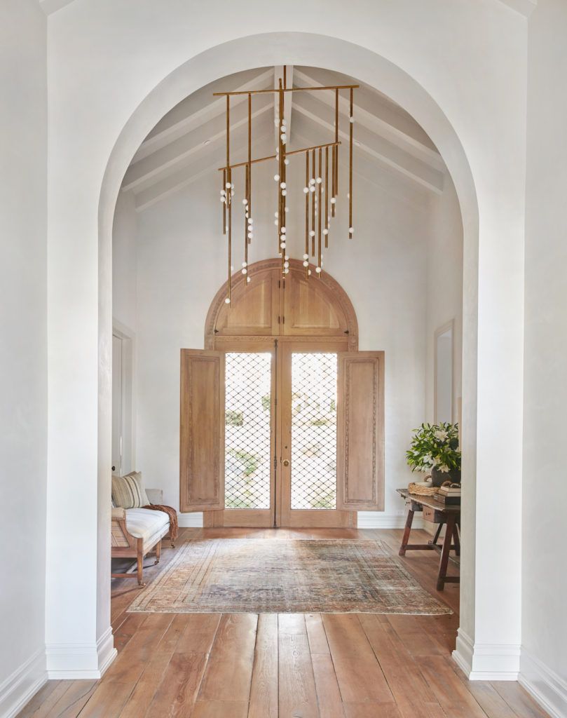 Brass Chandelier in Neutral Entryway Design by Amber Interiors