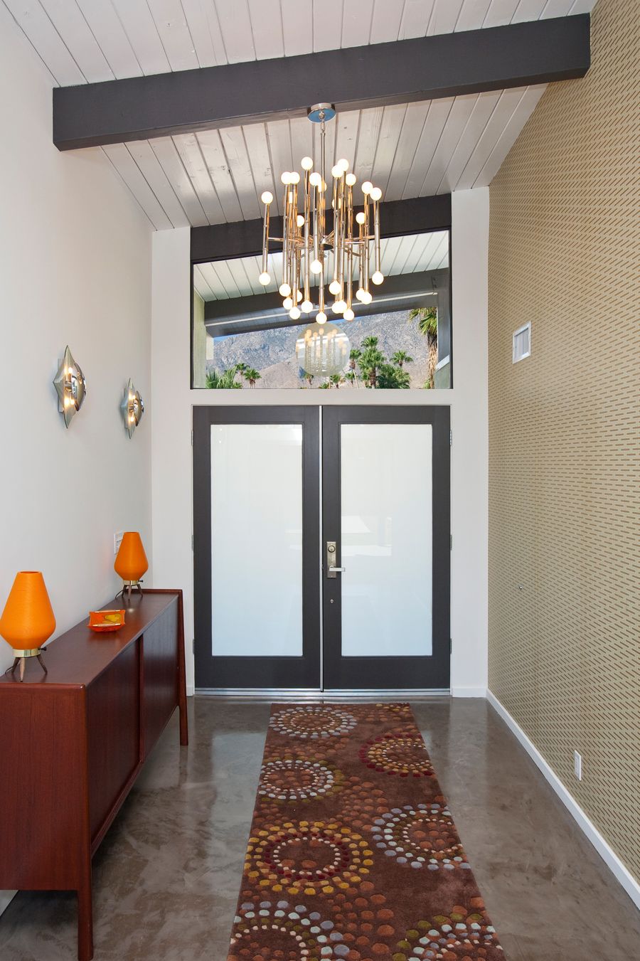 Brass Rod Chandelier in Mid-century Entryway via Nuvue Interactive