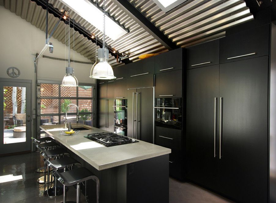 Concrete Countertops in Black Industrial kitchen design via Renovation Design Group