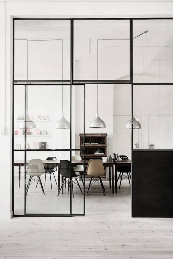 Salle à manger industrielle avec vitres à cadre métallique noir