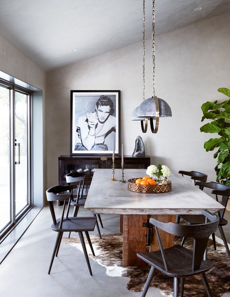 Iron Pendant Lights and Concrete Dining Table in Industrial Dining Room by Stash Home