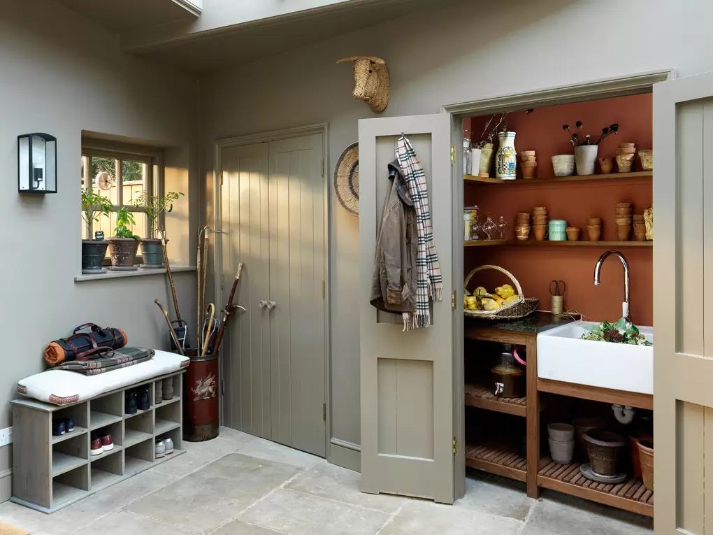 Mudroom with Shoe Storage and Farmhouse Sink in English Country House via K&H Design