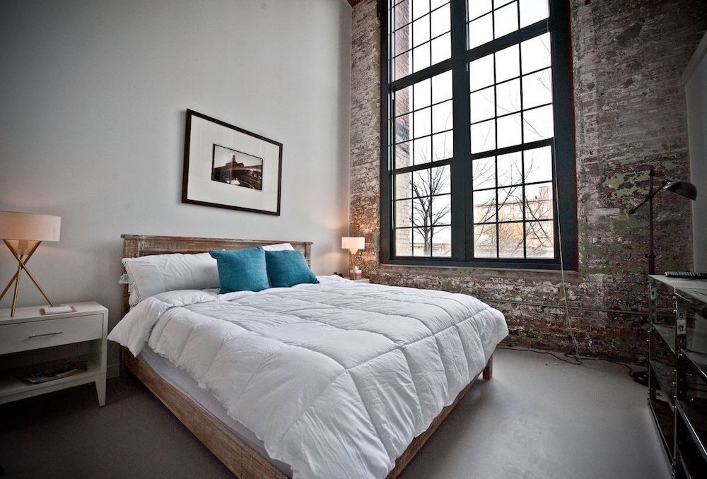 Rustic Wood Bed in Industrial Bedroom via Heirloom Design Build