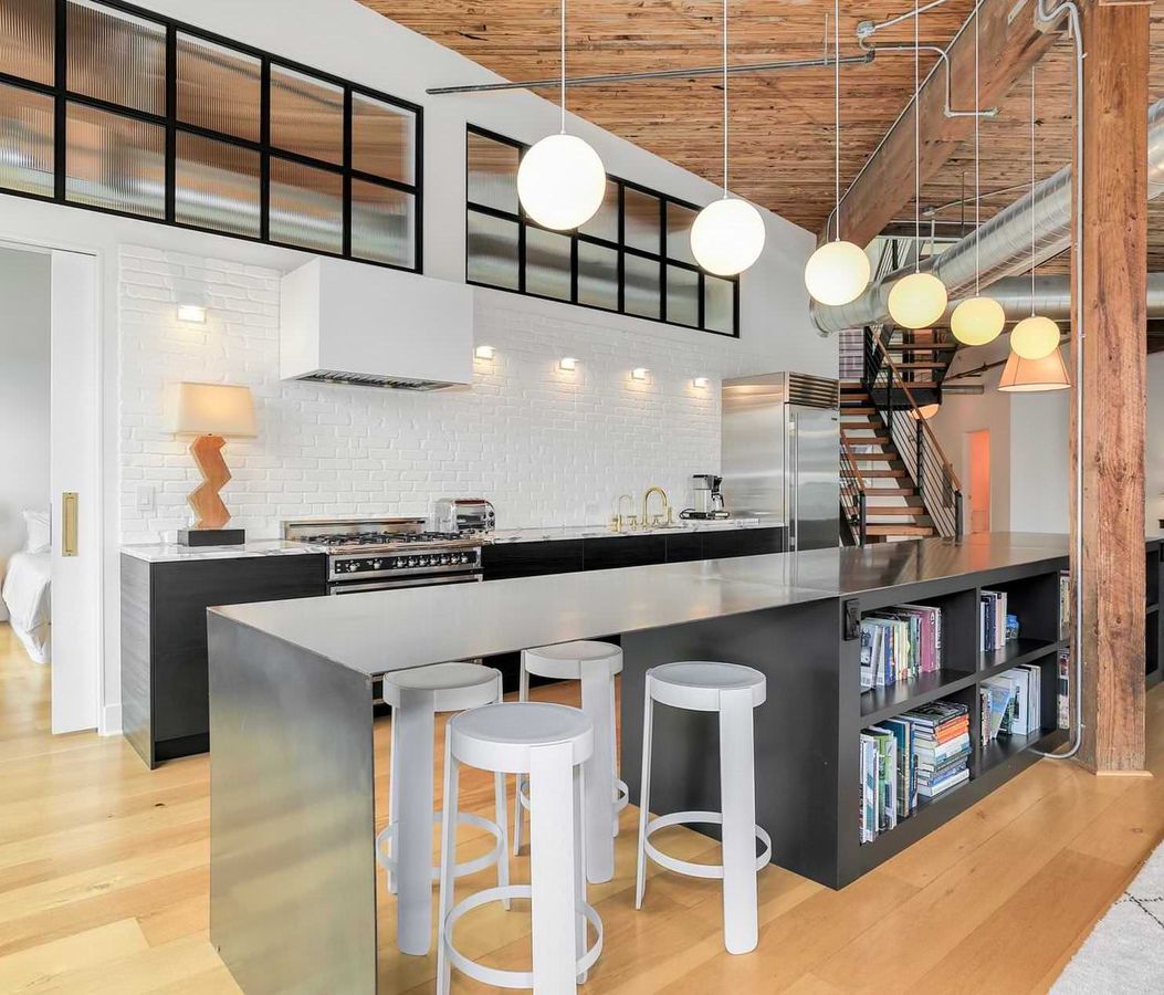 White Metal Bar Stools and white brick wall in Industrial Kitchen with Sphere Pendant Lights via Gant Nychay Architecture