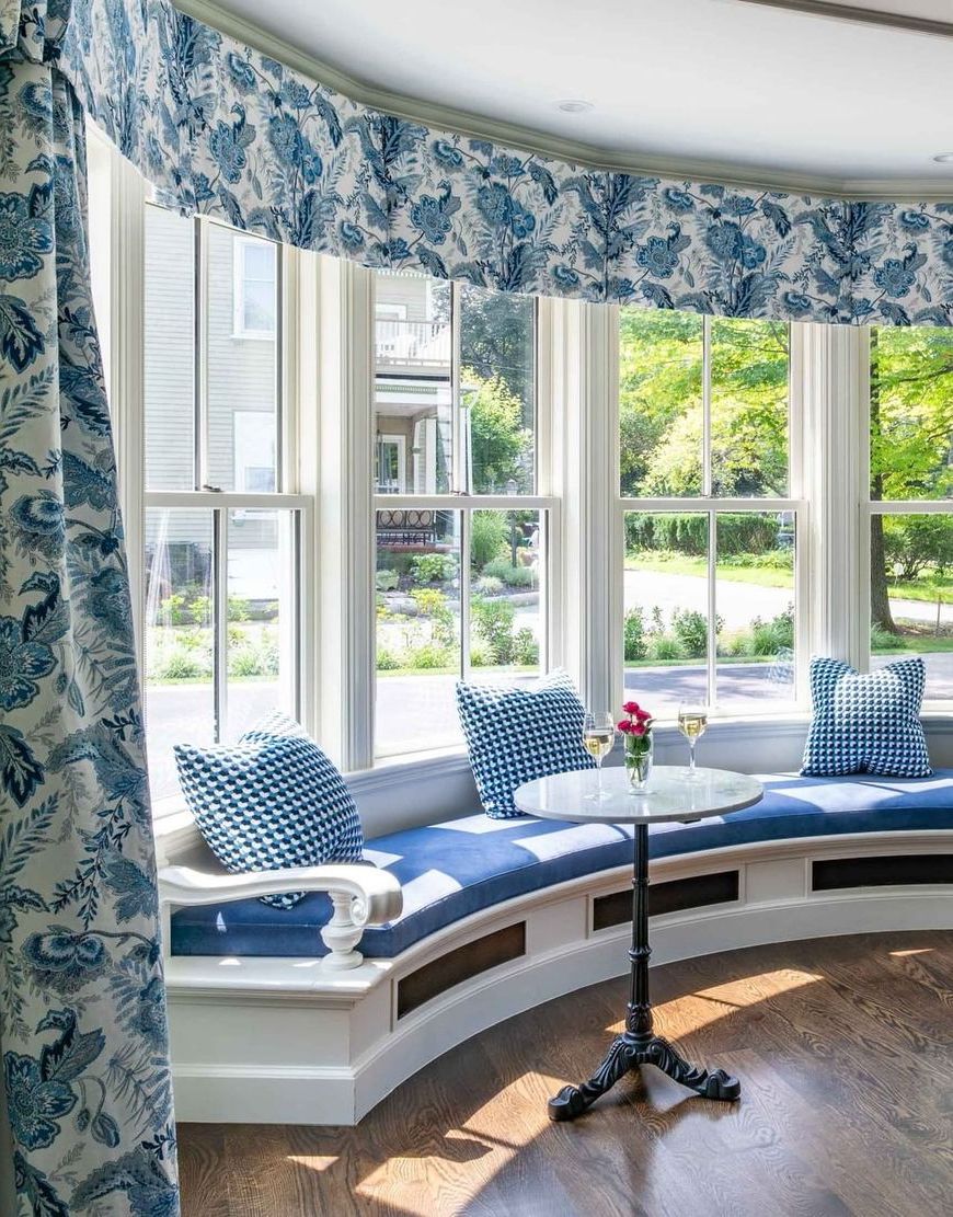 Blue floral curtains and bay window seating with marble French Bistro Tables via Liz Caan