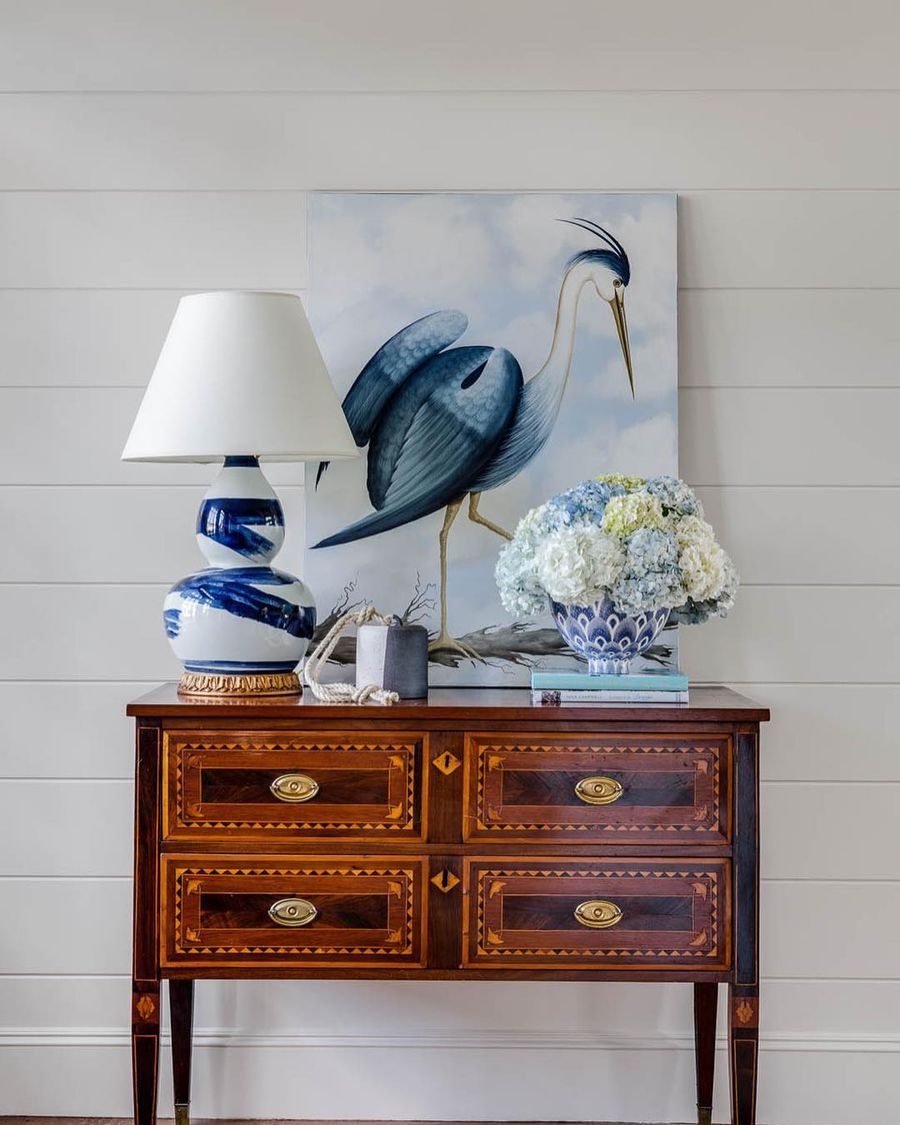 Coastal Vignette with Pelican Art, table lamp, coastal books, hydrangeas via @digsdesignco