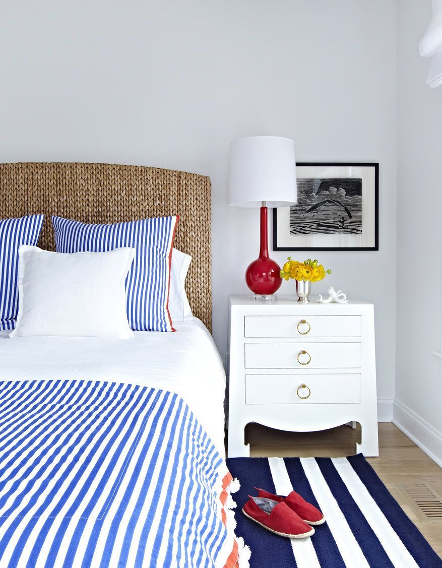 Nautical Bedroom with Wicker Headboard, blue striped sheets, and red table lamp via Chango and Co design