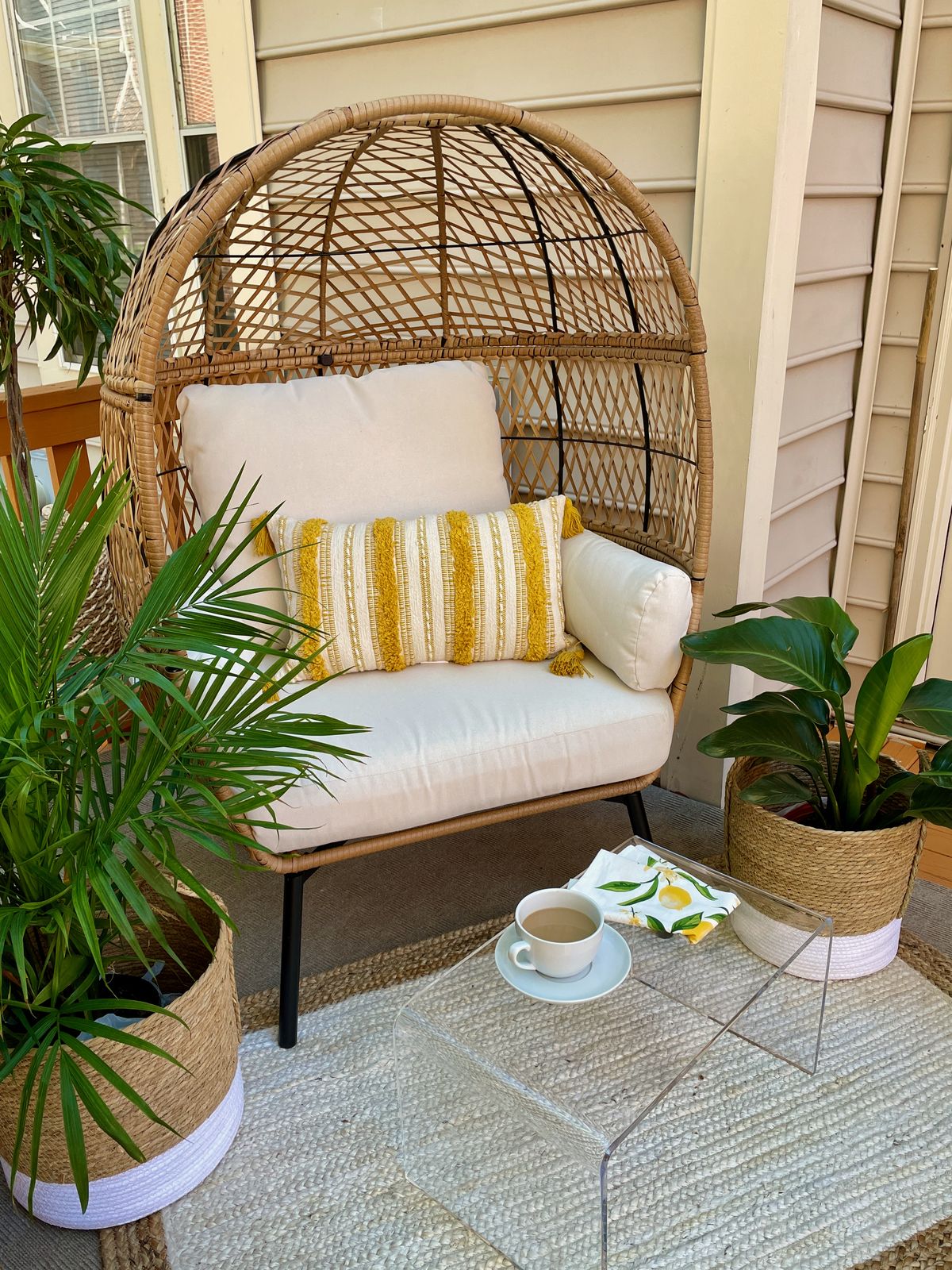 Yellow Citrus Summer Patio Decor Update with Egg Chair, Yellow Pillow, Glass table, jute rug, jute planters, majestic palm and lemon cloth napkins from Walmart