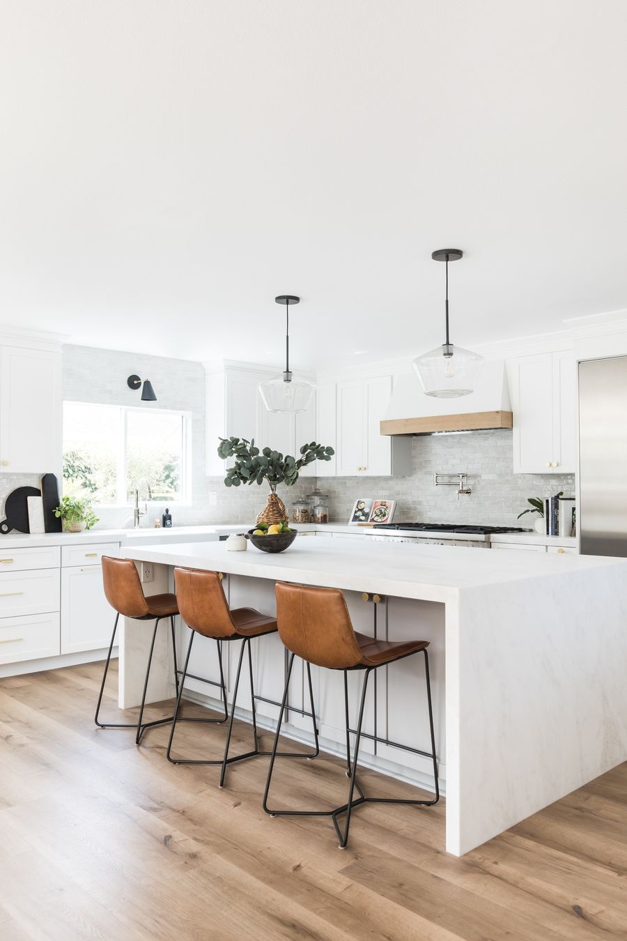 Minimalist kitchen with brown leather counter chairs via puresaltinteriors