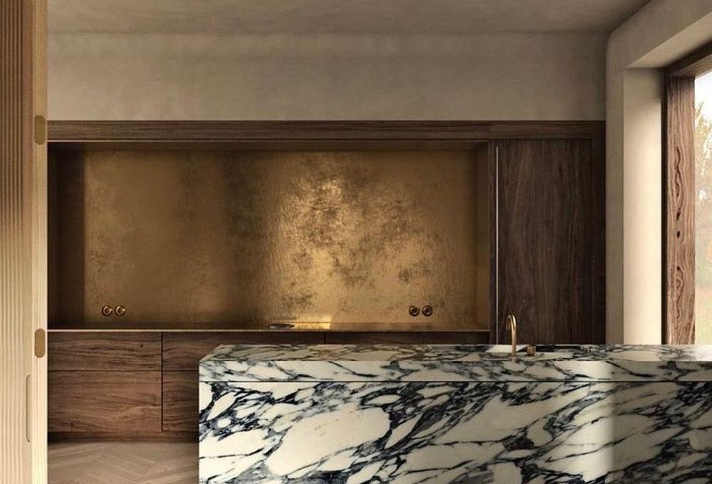 Aged brass kitchen backsplash with marble island @rinalovko.studio