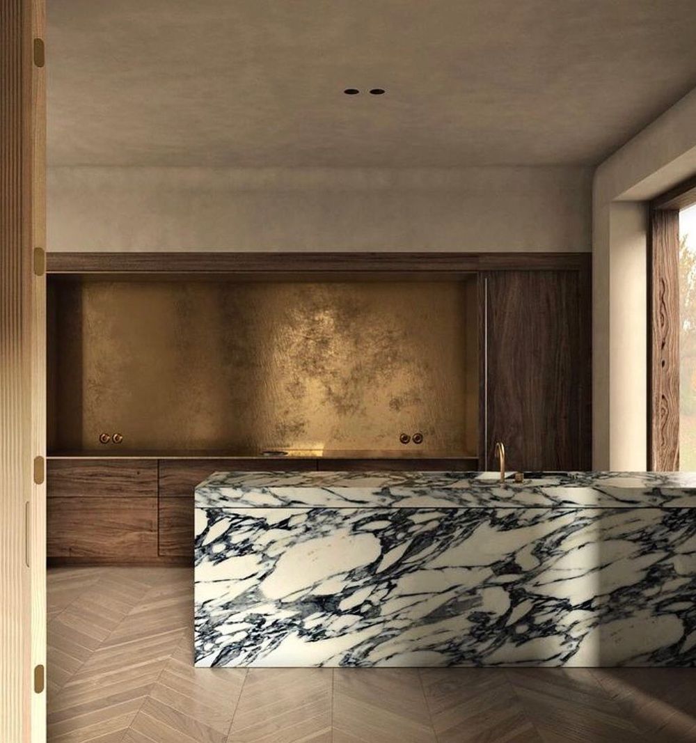 Aged brass kitchen backsplash with marble island @rinalovko.studio