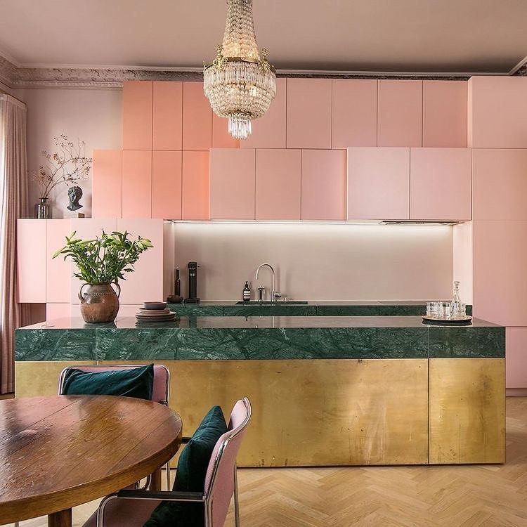 Brass kitchen island with green marble counters and pink cabinets @einarjoneronning