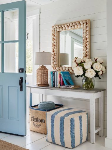 Beach home entryway with striped cushion seating and blue front door concept