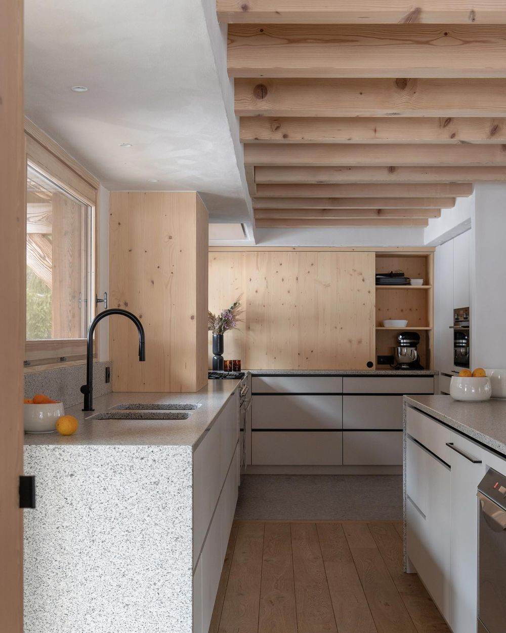 Ski Chalet Kitchen unfinished wood beams terrazzo countertops by_interieursdarchitectes