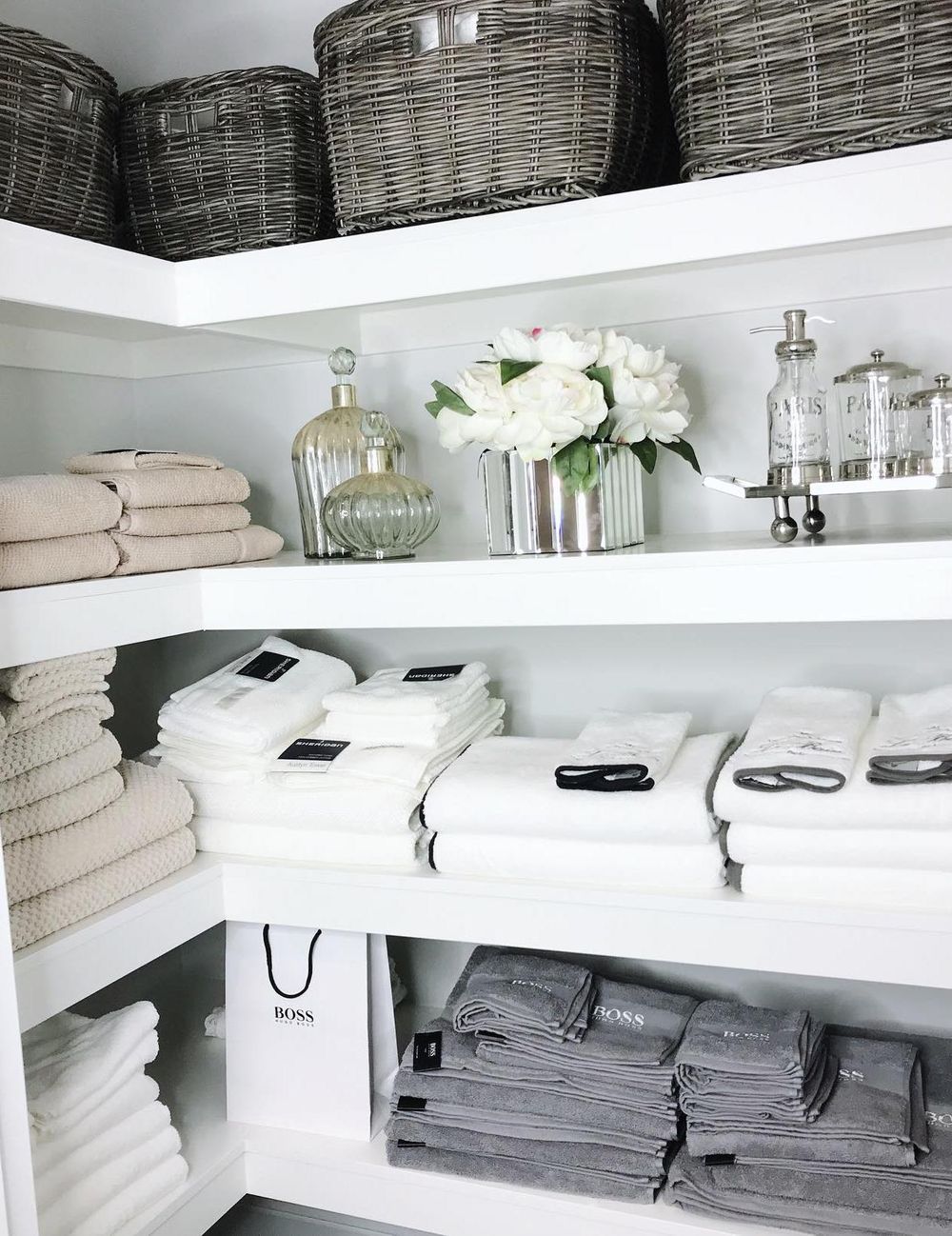 bathroom organization towels neatly folded on shelves hamptonluxuryhome