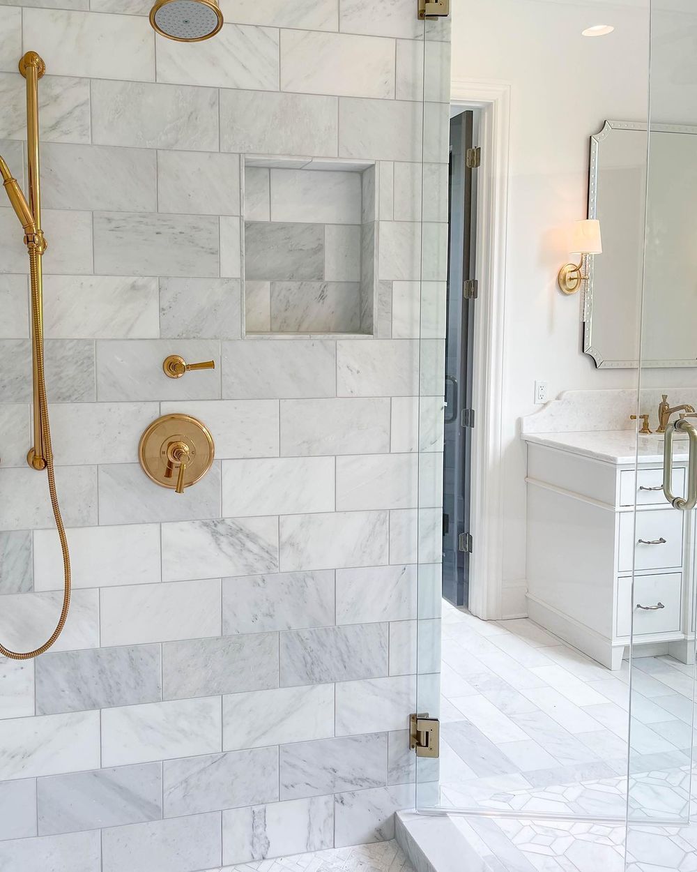 shower niche in marble tile bathroom with brass hardware bairdgrahamcompany